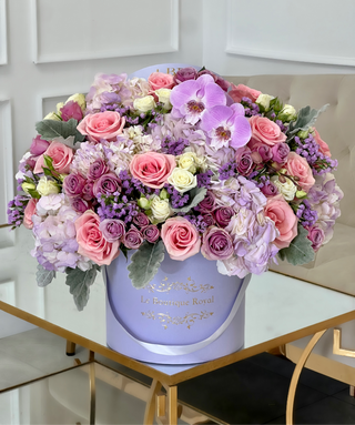 Arreglo floral mixto de flores de color púrpura en un jarrón de lavanda