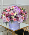 Arreglo floral mixto de flores de color púrpura en un jarrón de lavanda