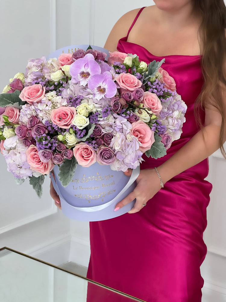 Una mujer sosteniendo un arreglo floral con rosas y otras flores