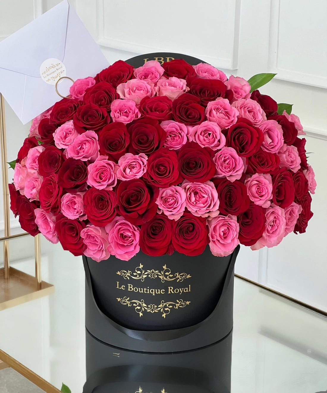 Rosas rojas y rosadas en un jarrón negro