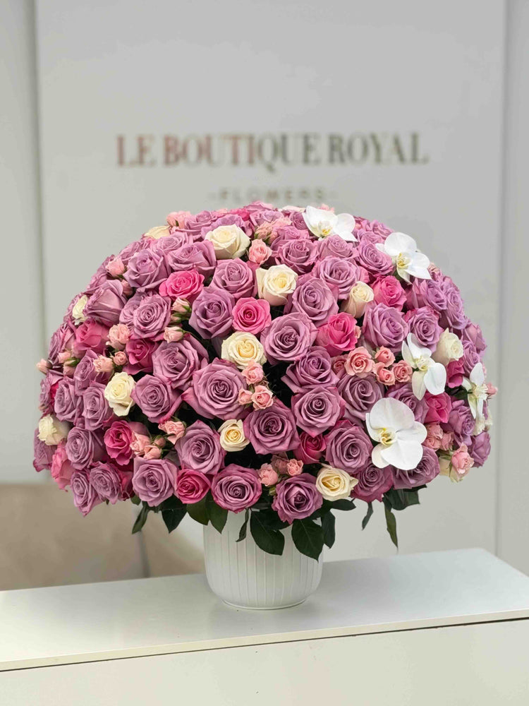 Arreglo floral de lujo con rosas lavanda, rosas spray rosadas, rosas marfil y orquídeas blancas en un jarrón elegante de Le Boutique Royal