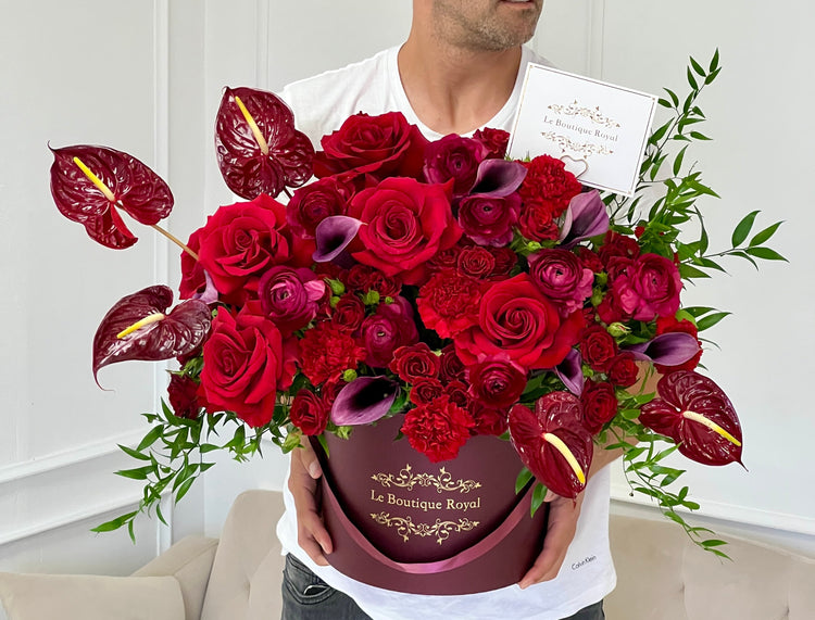 a person holding red flowers