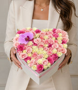 Jardinera de flores de lujo en forma de corazón con rosas rosadas y blancas y una orquídea morada de Le Boutique Royal en Miami.
