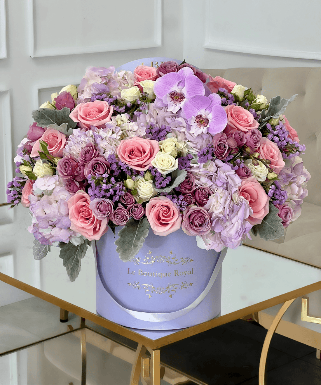 mixed flower arrangement of purple flowers in a lavender box vase