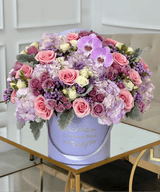 Arreglo floral mixto de flores de color púrpura en un jarrón de lavanda