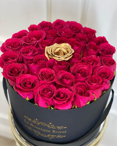 
                    
                      Rosas de color rosa intenso con una rosa dorada
                    
                  