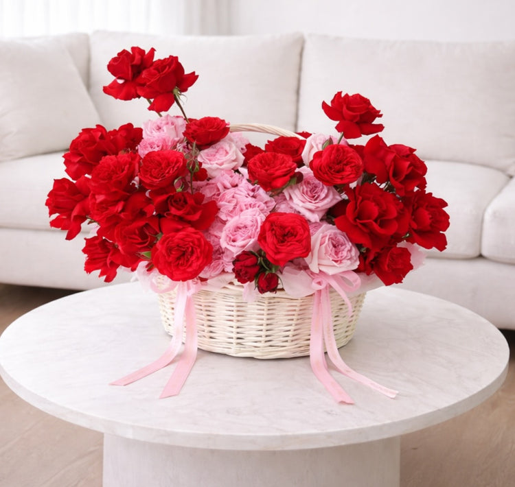 Cesta de flores con rosas rojas y rosadas