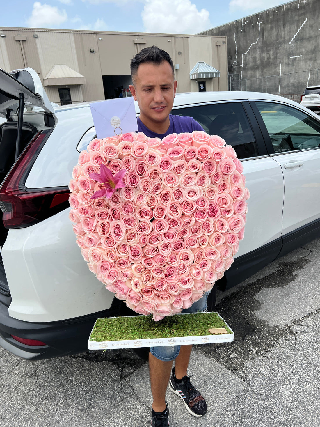 Corazón de rosas rosadas junto a un hombre