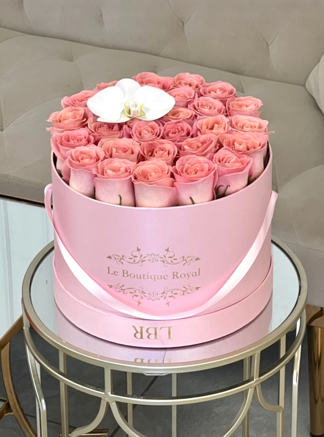 Rosas rosadas con orquídeas en una caja firmada