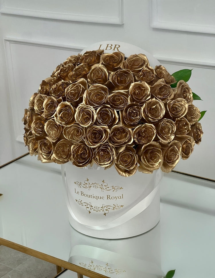 gold roses sprayed with gold on top of fresh roses