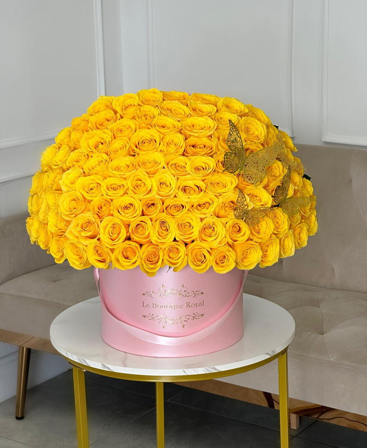 100 yellow roses in a pink vase with gold butterflies