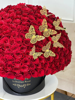 
                    
                      Mariposas doradas y rosas rojas en un jarrón
                    
                  